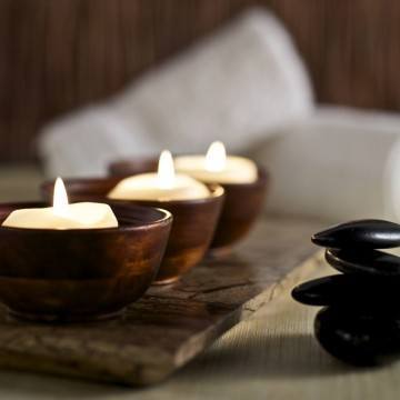 Candles and stones in a calm zen spa environment.